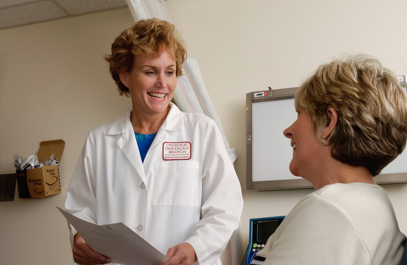 A clinician in a white coat talking with a patient.