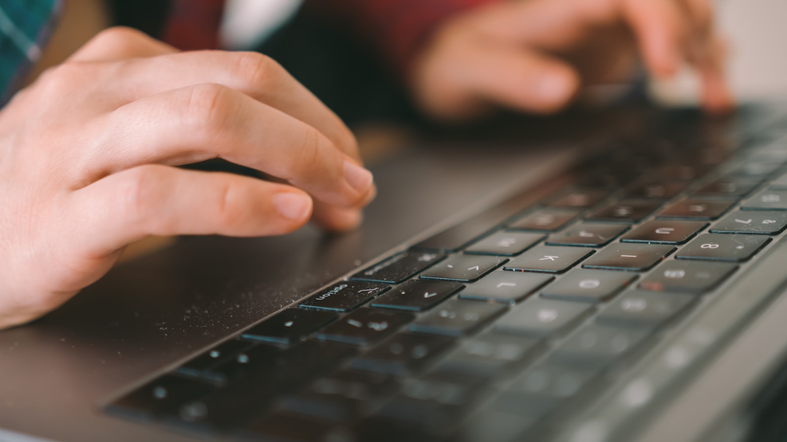 Hands on a black computer keyboard at a desk, representing the decision to move a small business website off Squarespace to WordPress