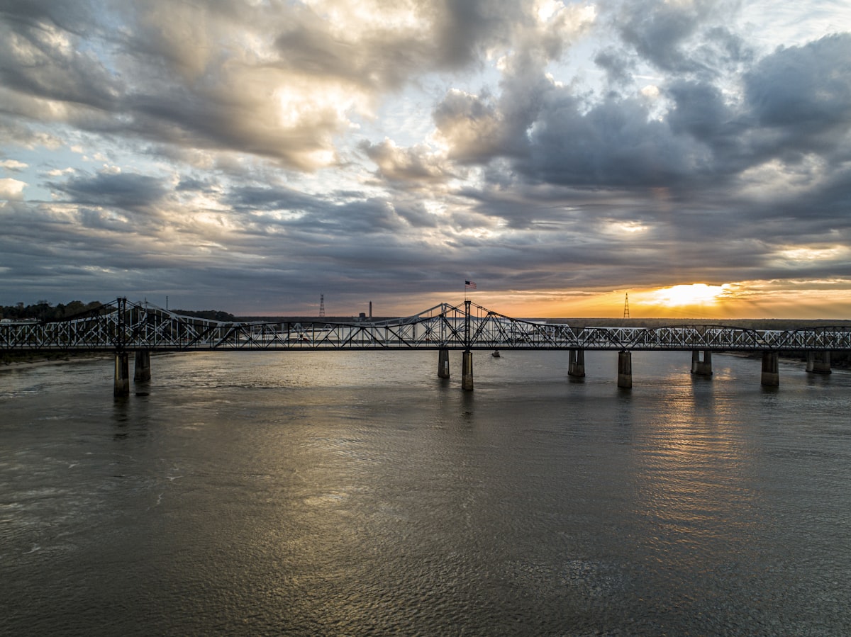 Bridge over the Mississippi River at sunset, representing the Iowa-Illinois state line in the Quad Cities