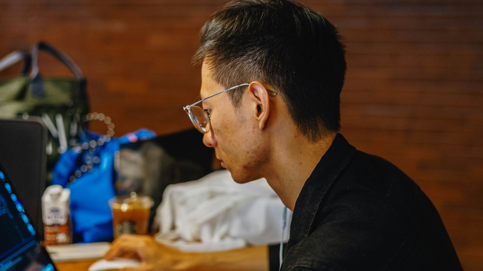 Small business owner reviewing their existing website on a laptop at a wooden desk before deciding whether to redesign