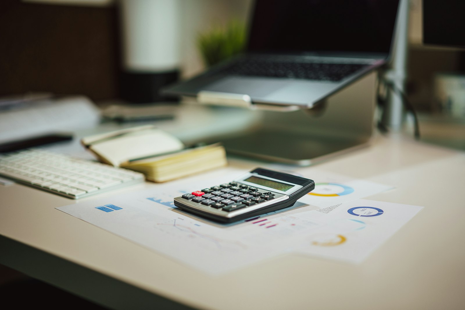 Calculator and laptop on a desk representing website maintenance cost planning for a small business