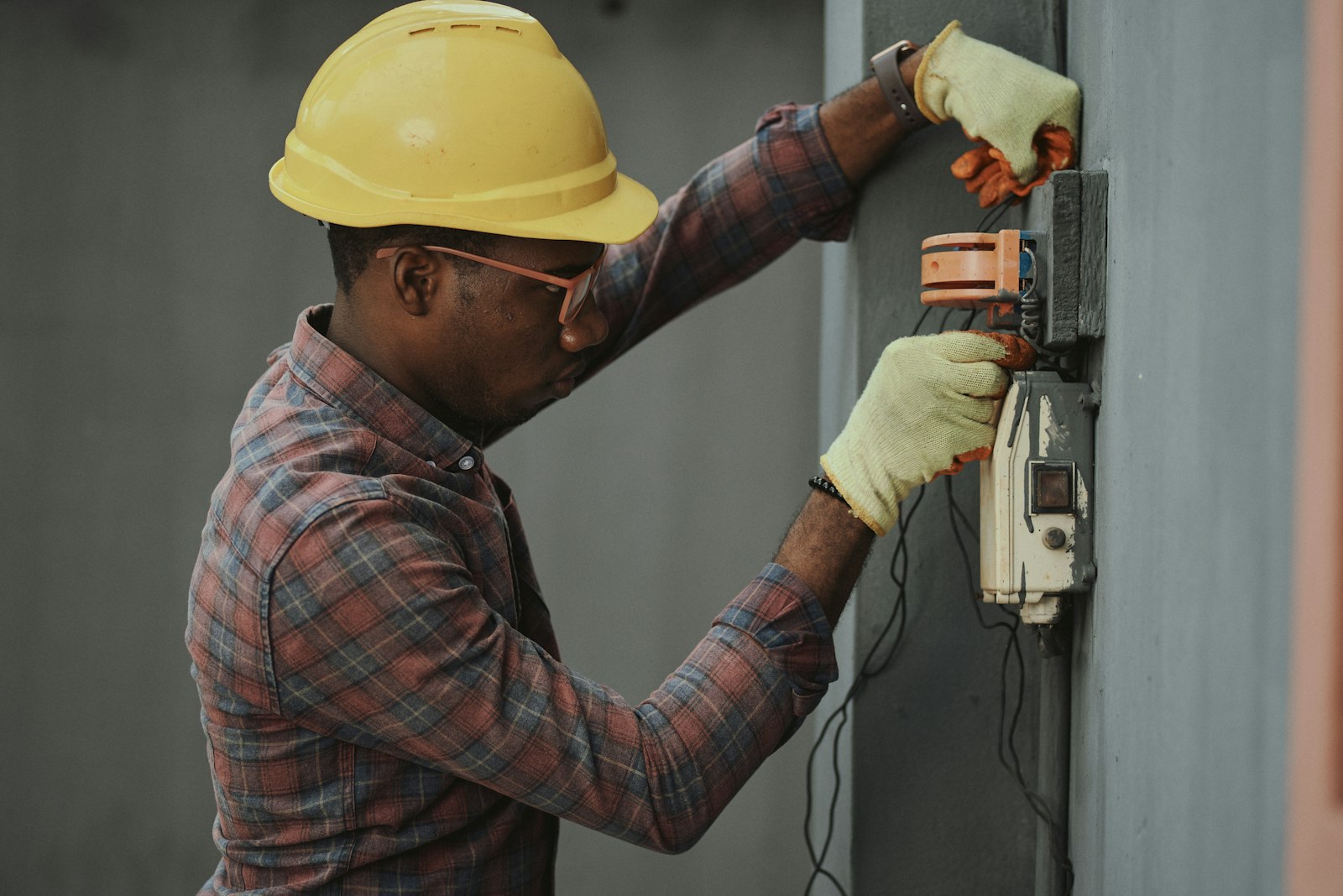 Service technician in safety gear performing equipment work, representing an HVAC contractor on a Quad Cities service call
