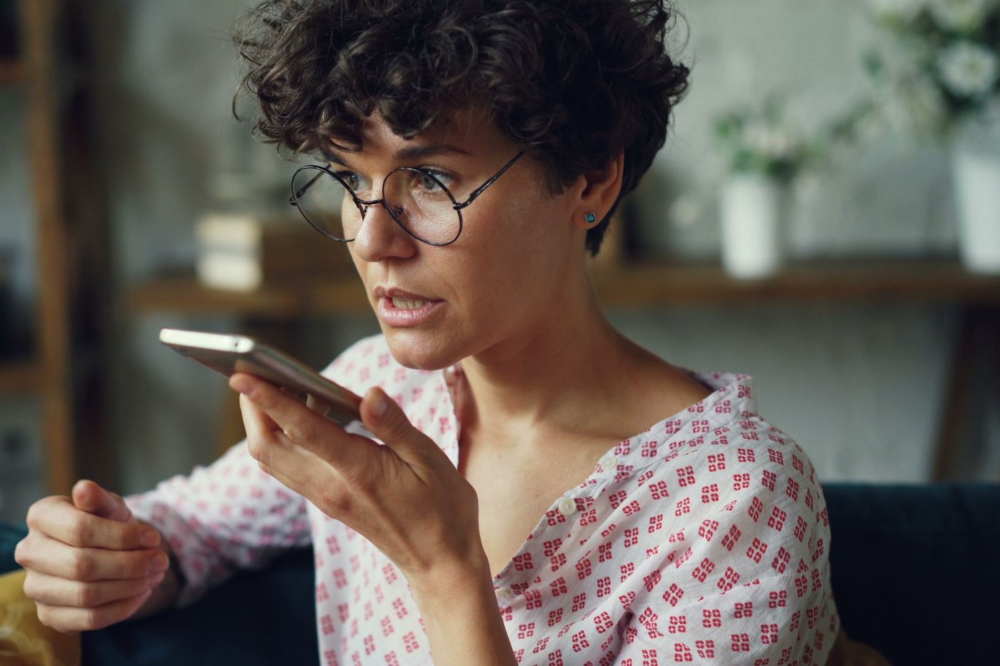 Woman speaking a question into her smartphone's voice assistant