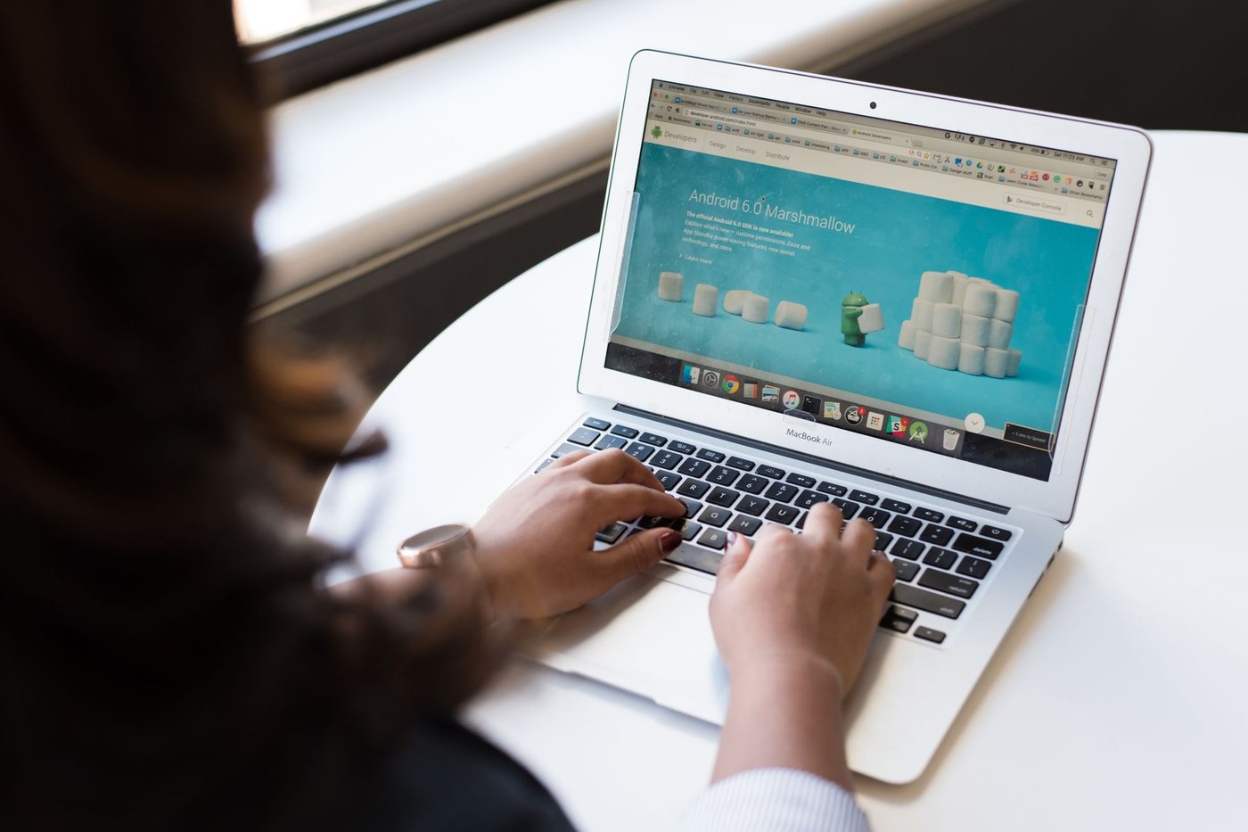 Person browsing a website on a laptop at a white table