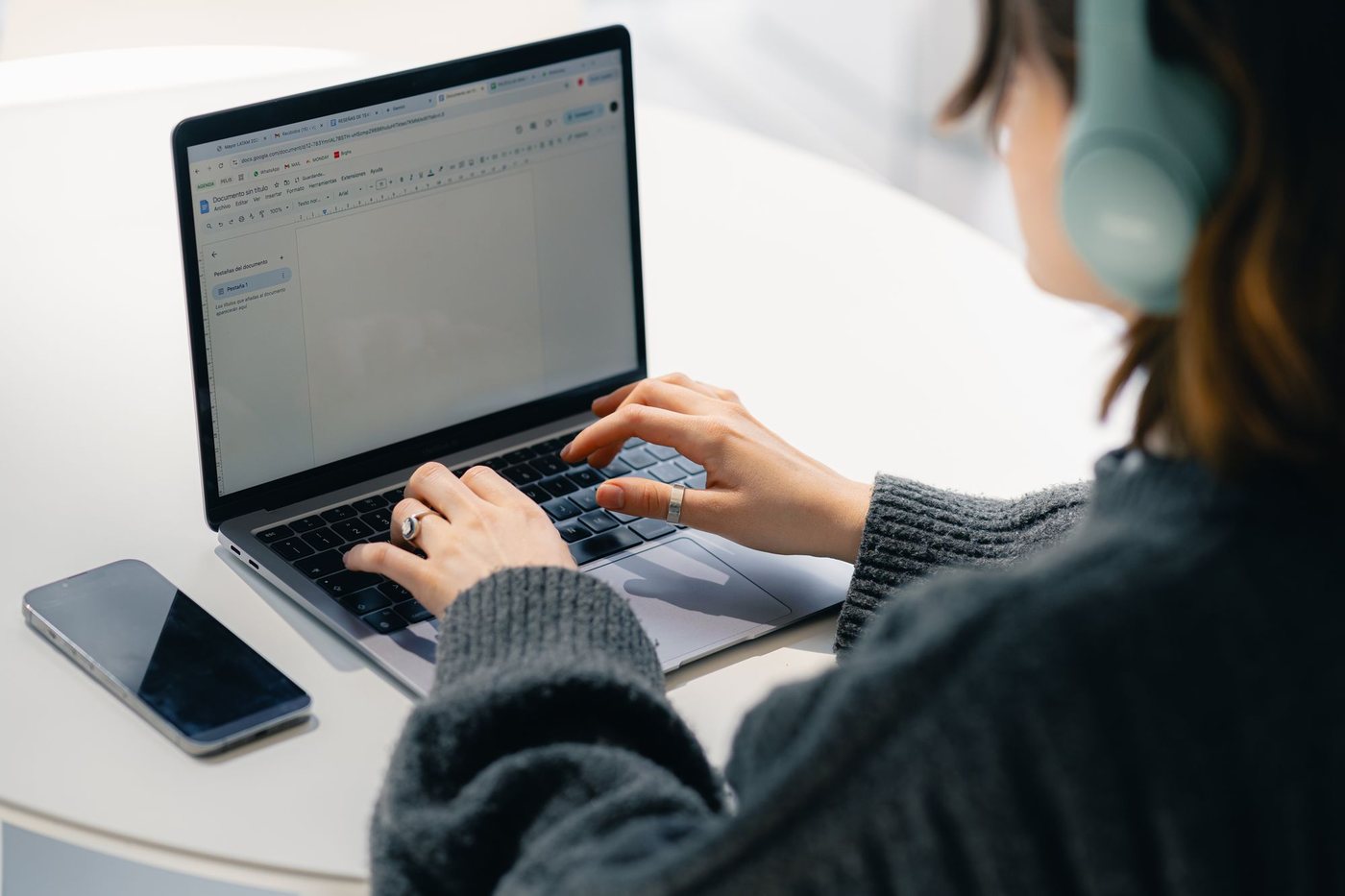 Office worker wearing headphones checking an email inbox on a laptop