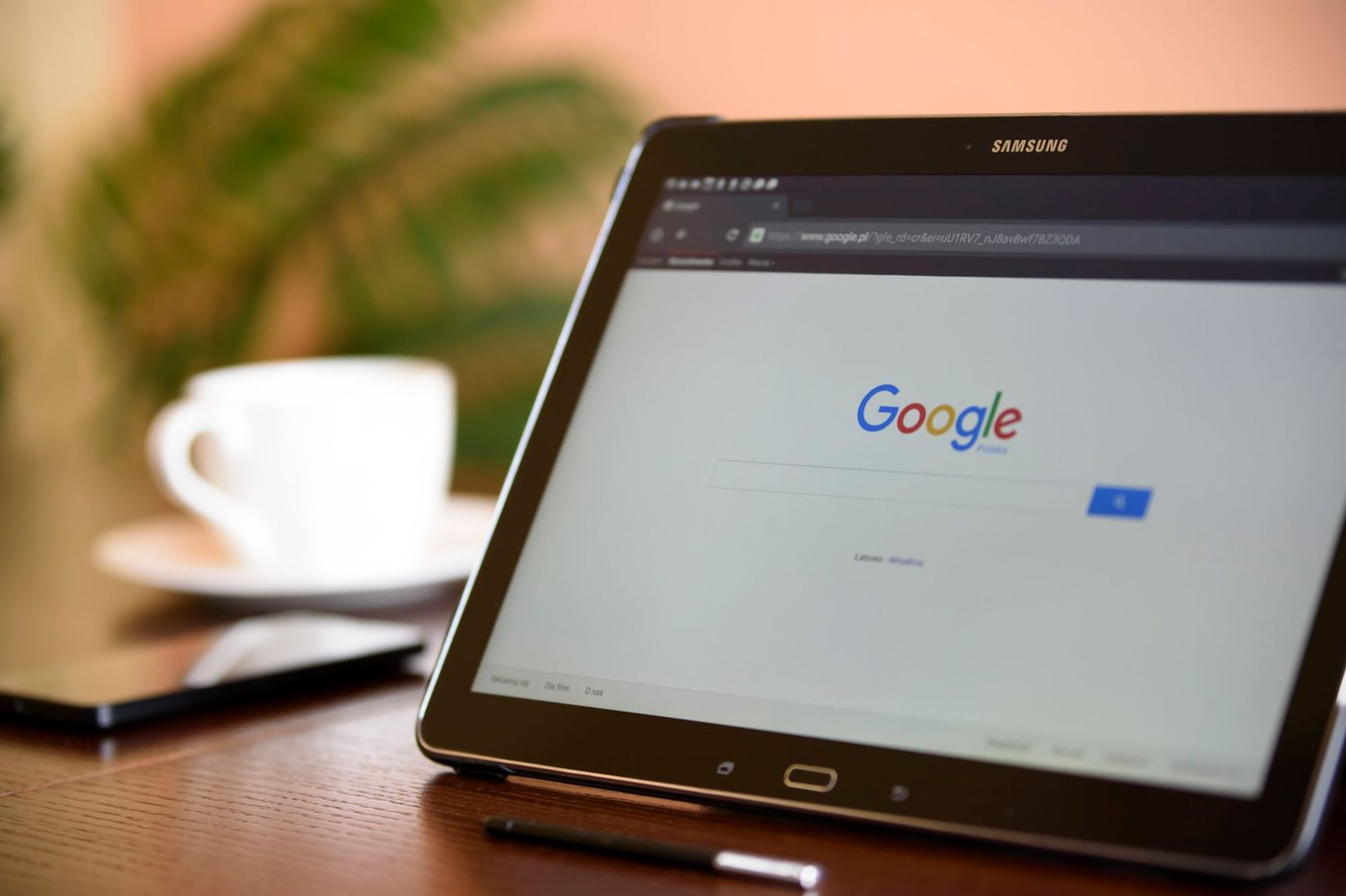 Tablet on a cafe table showing the Google search page