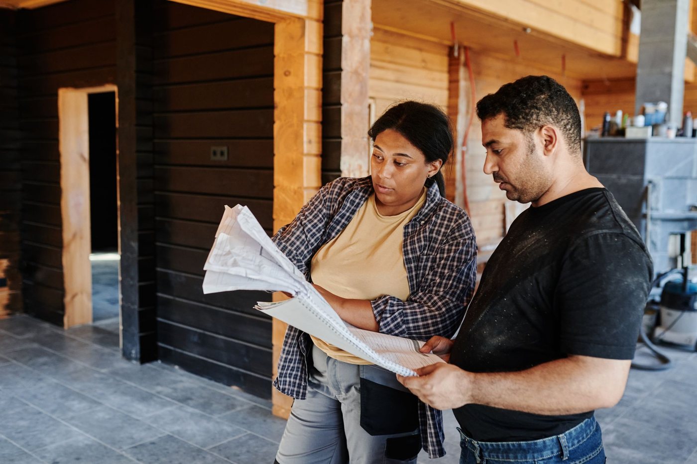 Contractor and homeowner reviewing renovation plans together inside a house
