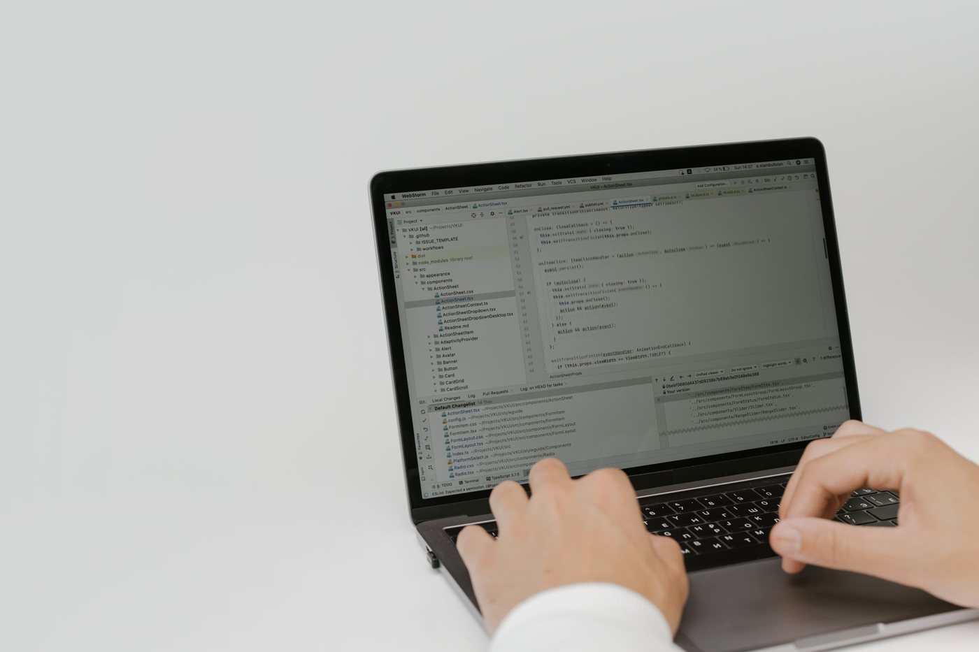 Hands typing on a laptop showing a list of software updates